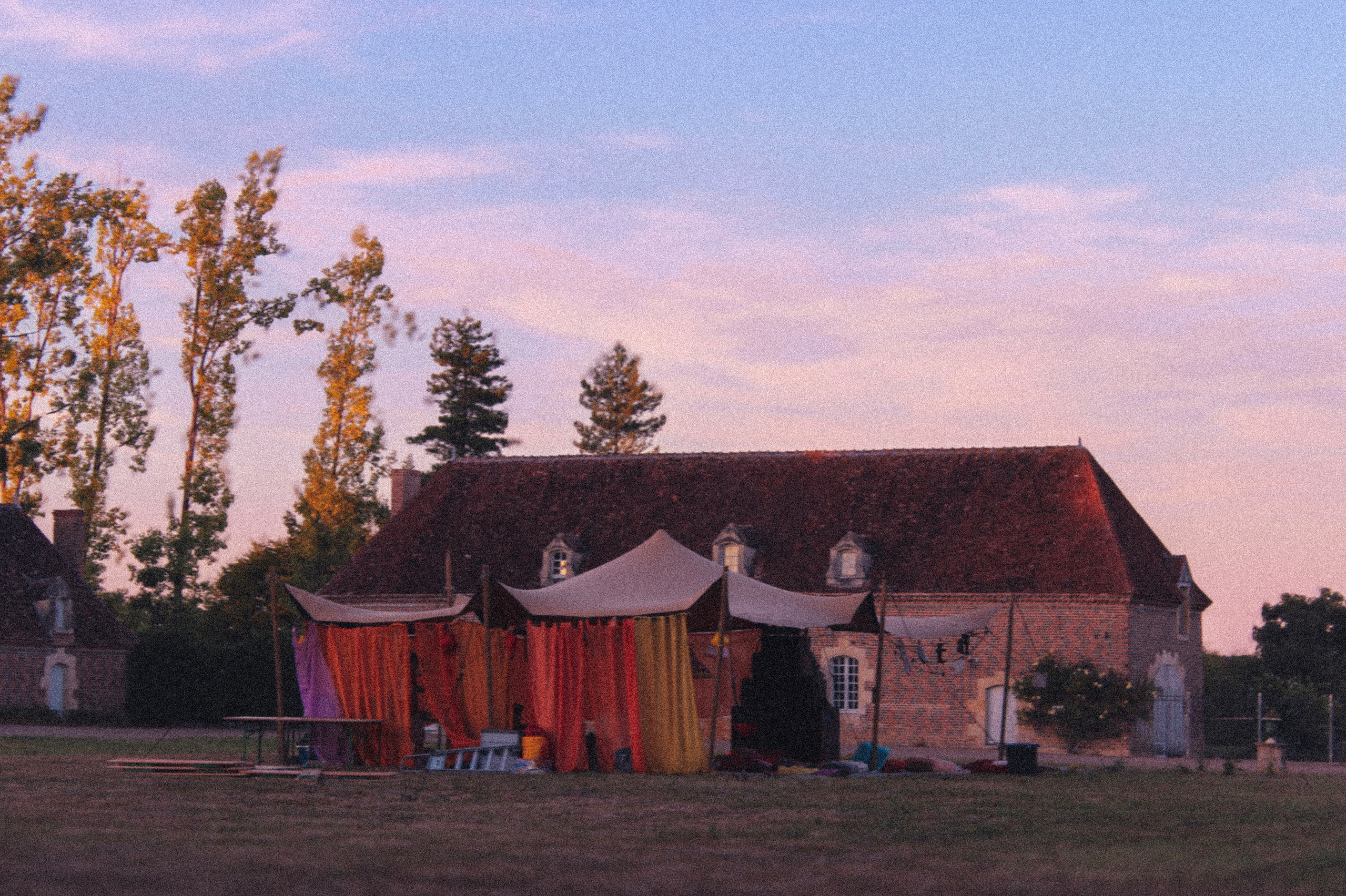 Dusk view of the brick building with a fabric pavilion in front