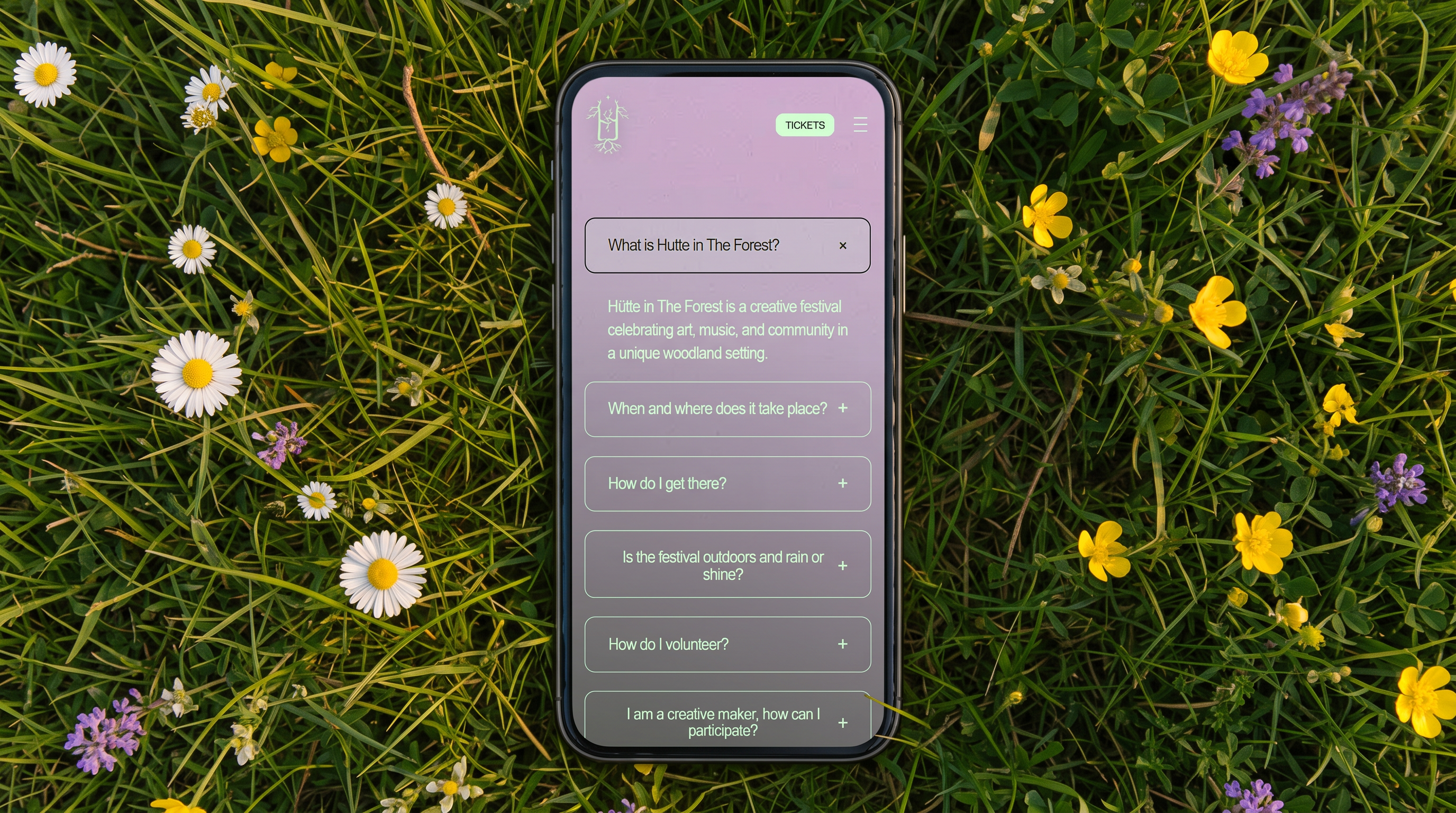 Hütte website on a phone in grass, showing the FAQ accordion