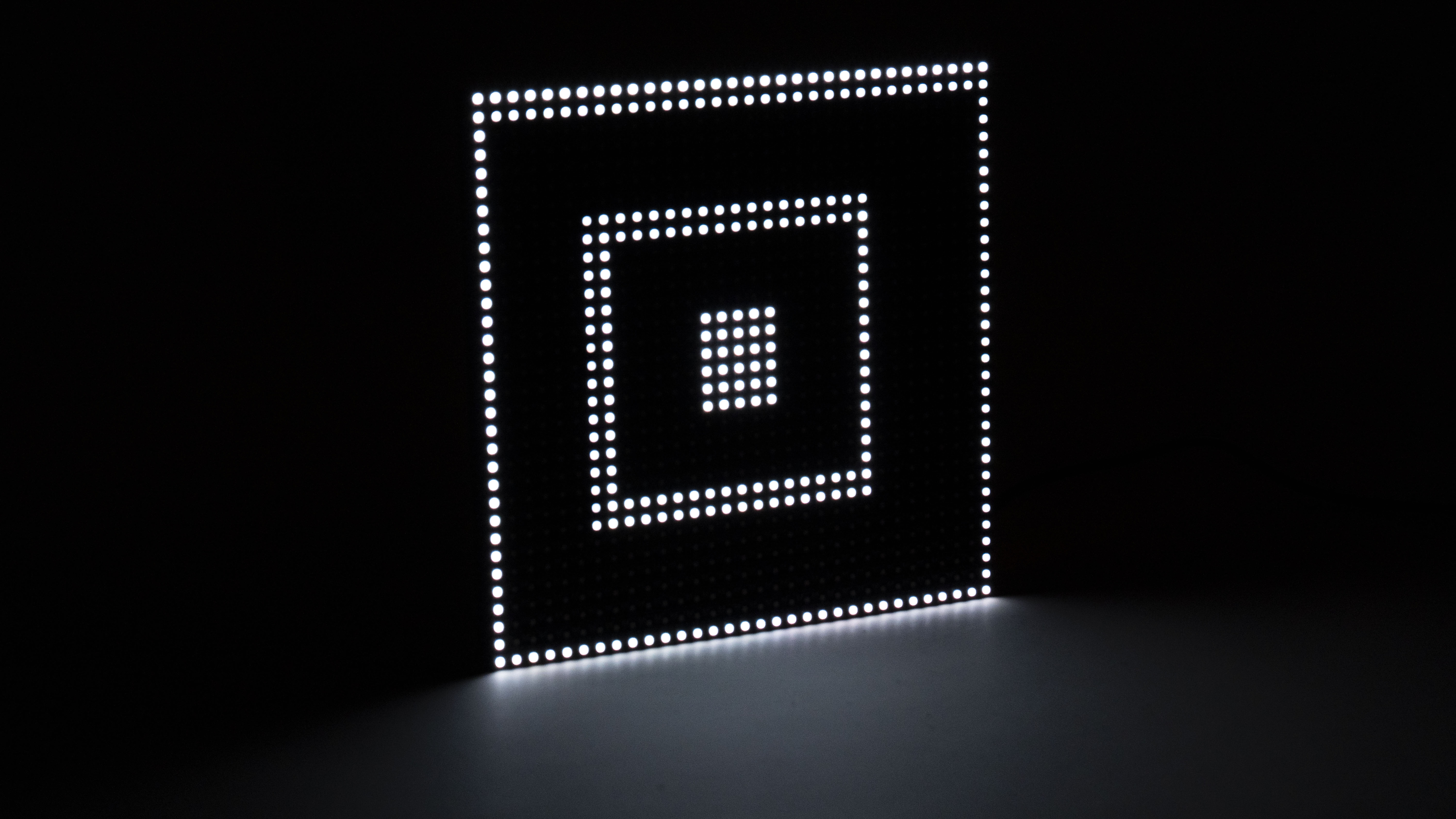 Nested square LED frames glowing in a dark space